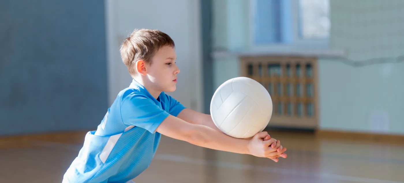 Kids playing volleyball mid-skill